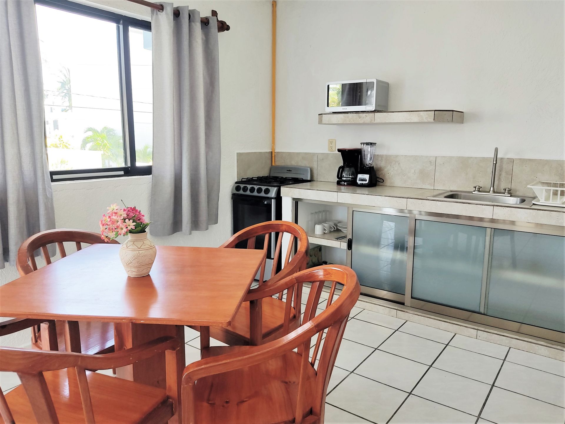 Una cocina con mesa y sillas y una ventana.