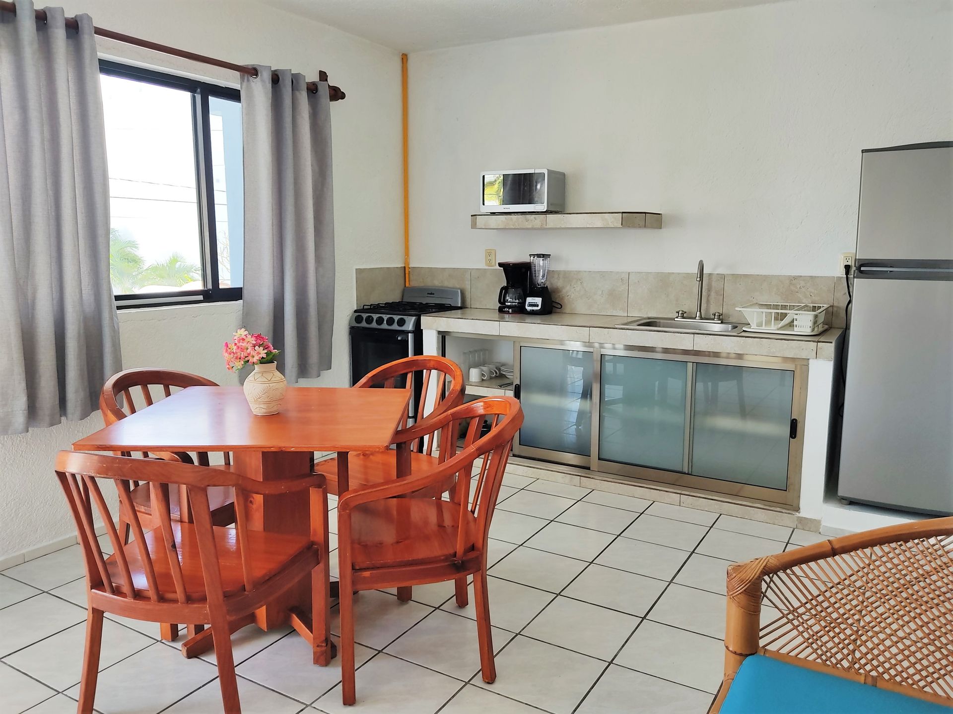 Una cocina con mesa y sillas y un refrigerador.