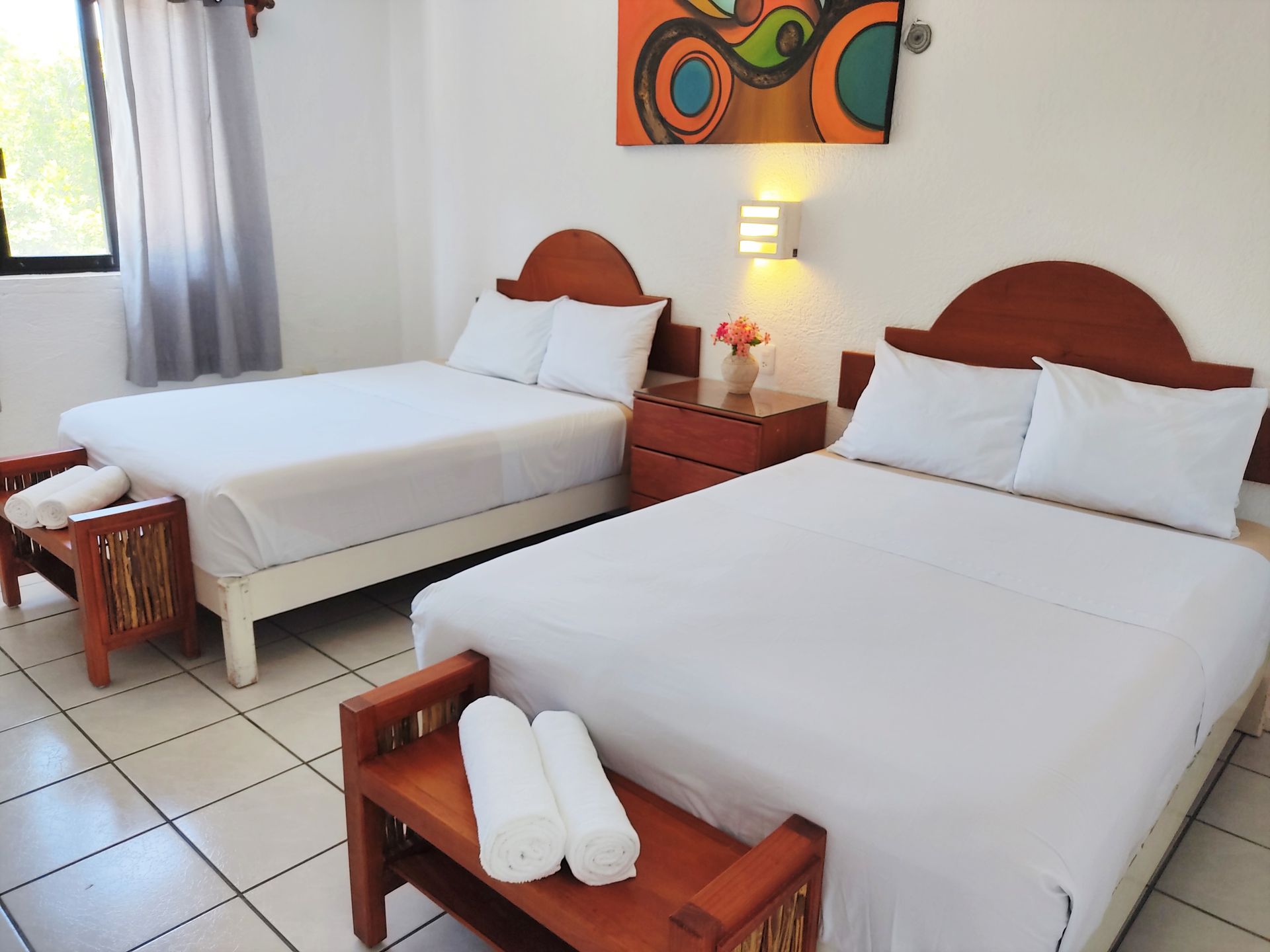 A hotel room with two beds and a bench