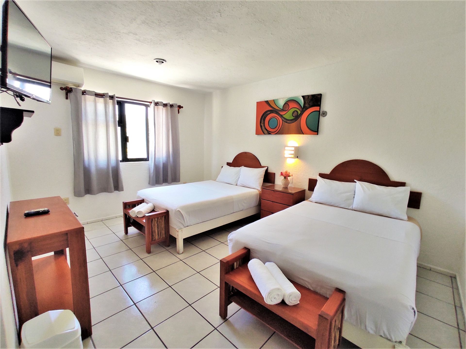 A hotel room with two beds and a flat screen tv