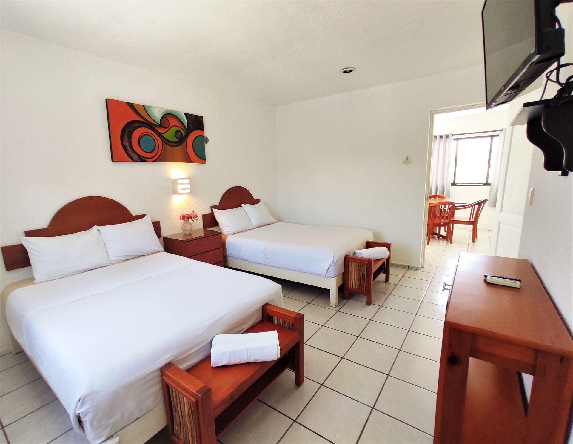 A hotel room with two beds and a flat screen tv