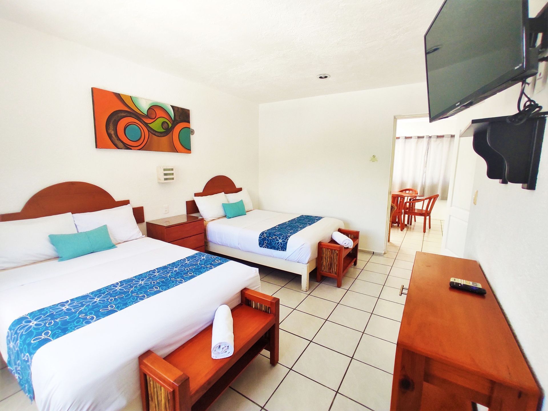 Una habitación de hotel con dos camas y un televisor de pantalla plana.