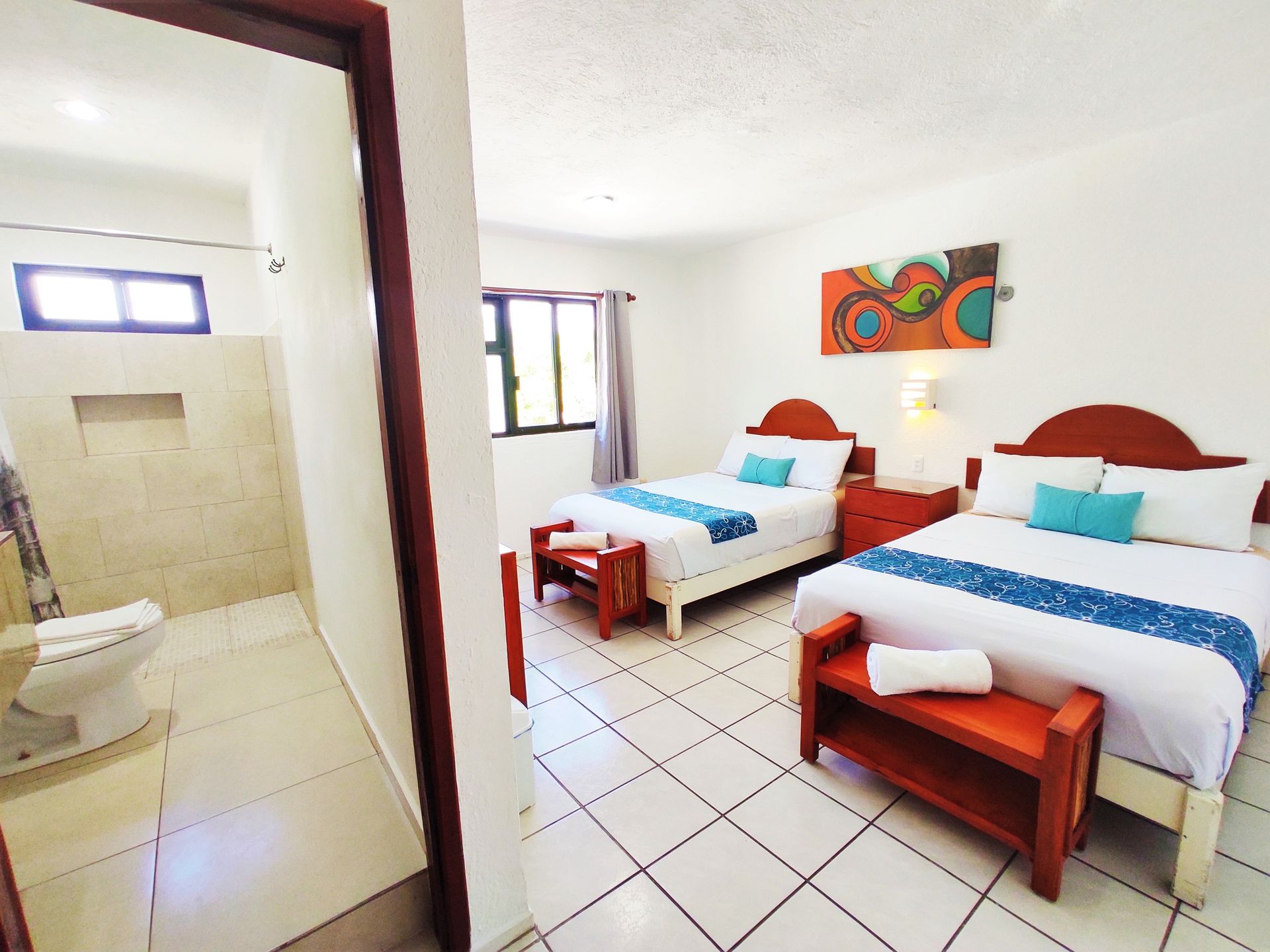 Una habitación de hotel con dos camas y un baño.