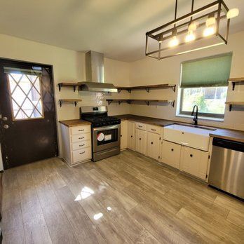A kitchen with a stove , sink , and dishwasher.