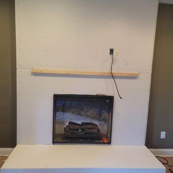 A fireplace is being built in a living room.