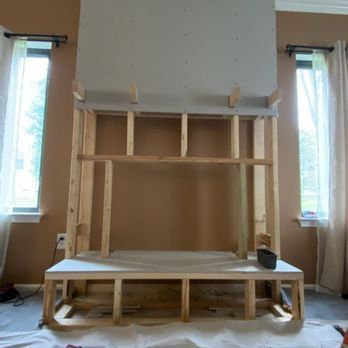A fireplace is being built in a living room