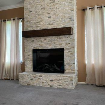 A living room with a fireplace and a flat screen tv.