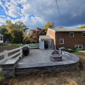 A brick house with a patio and a fire pit in front of it.