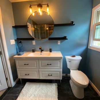 A bathroom with a sink , toilet and mirror.