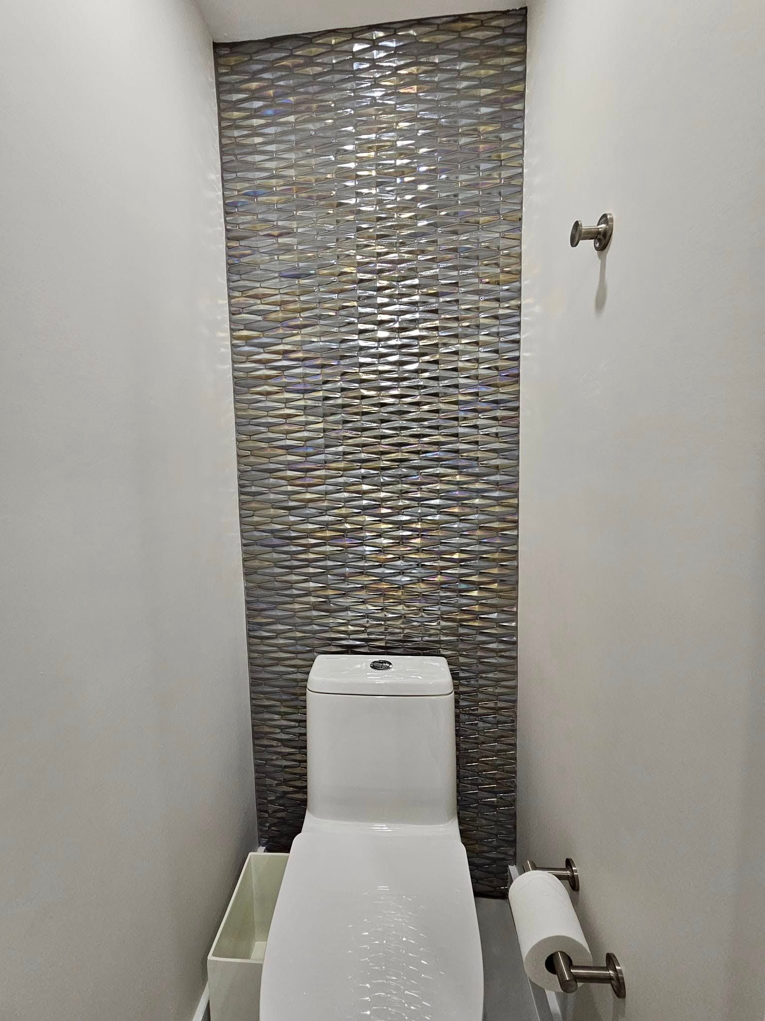 A small bathroom with a toilet and a paper towel holder.