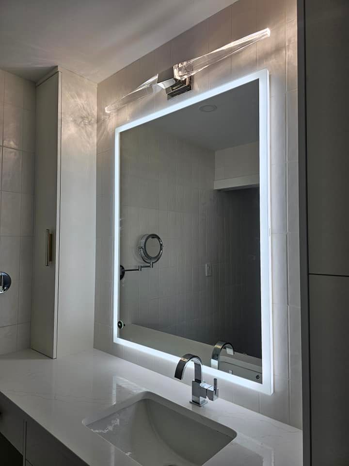 A bathroom with a large mirror and a sink.