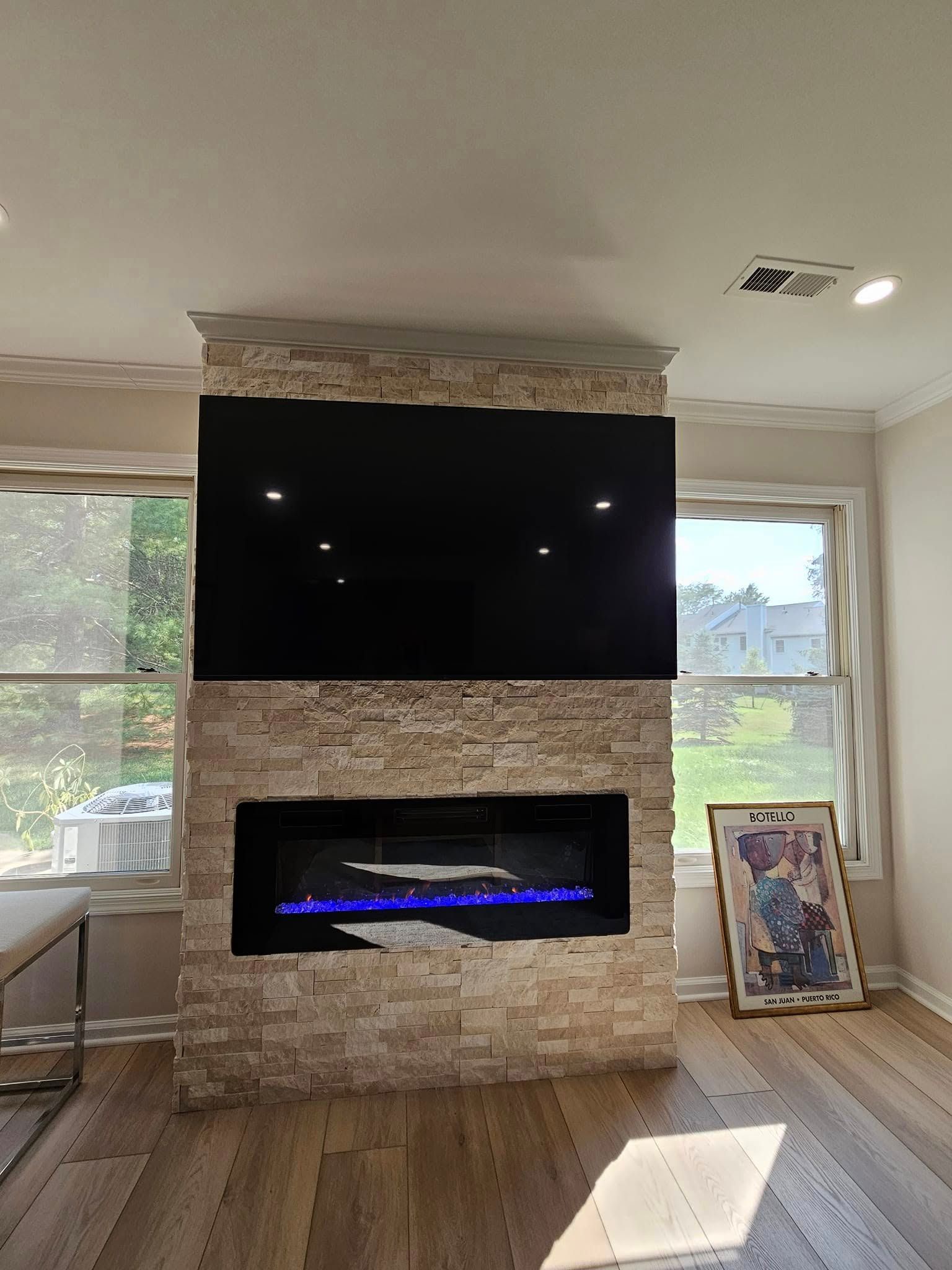 A living room with a fireplace and a flat screen tv.