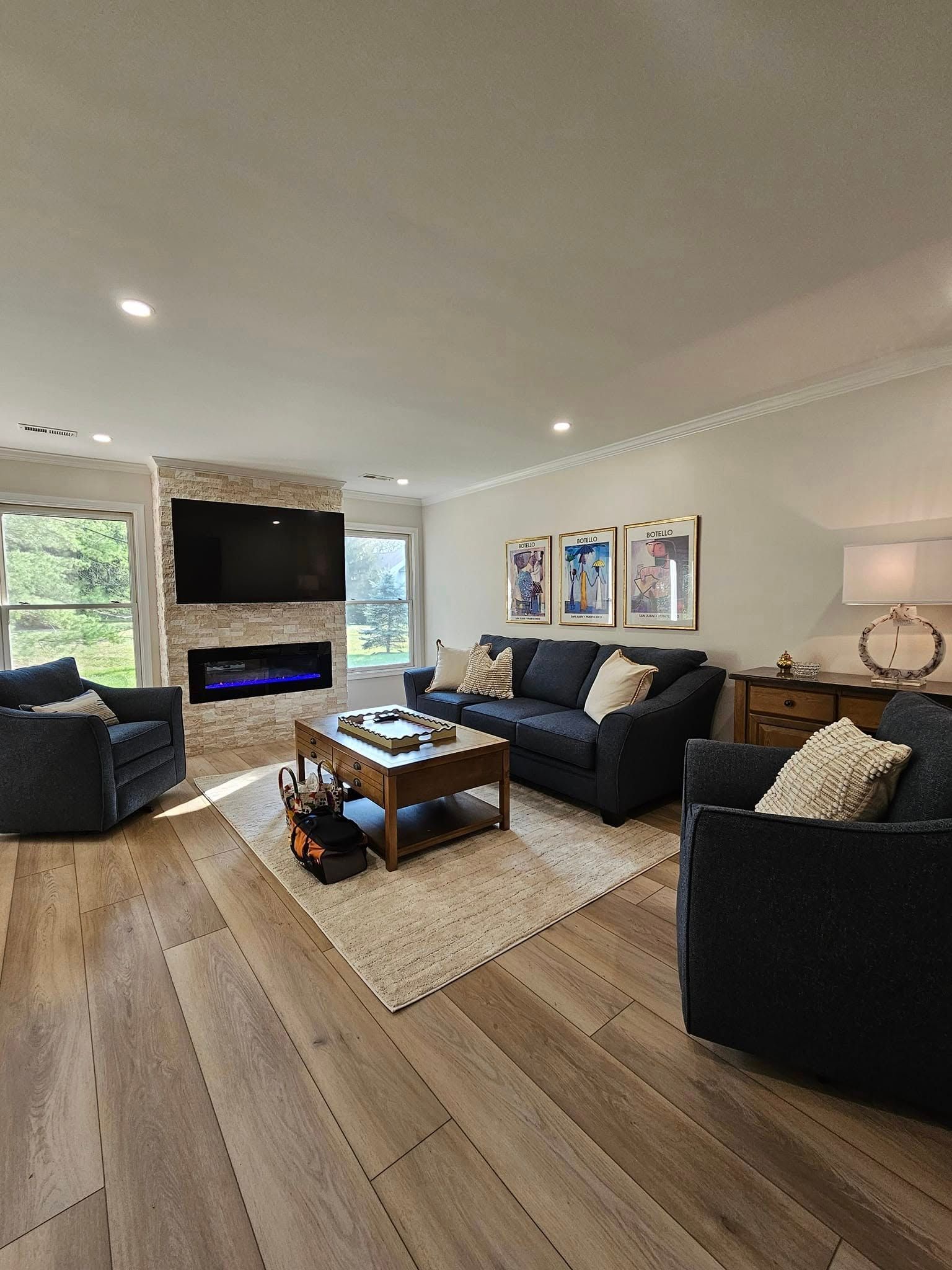 A living room with a couch , chairs , coffee table and television.