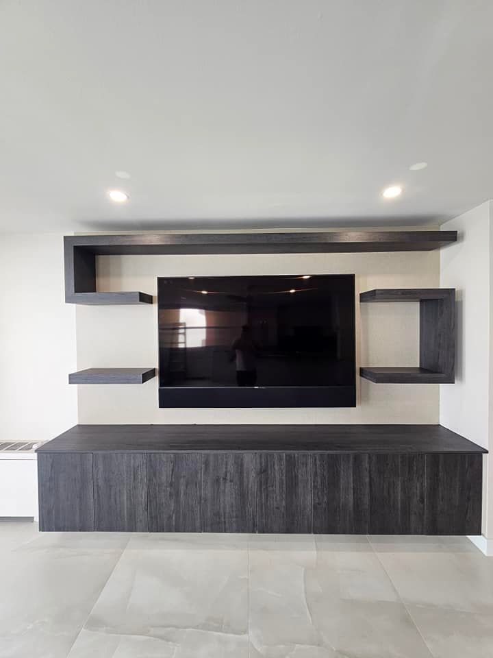 A living room with a flat screen tv mounted to the wall.
