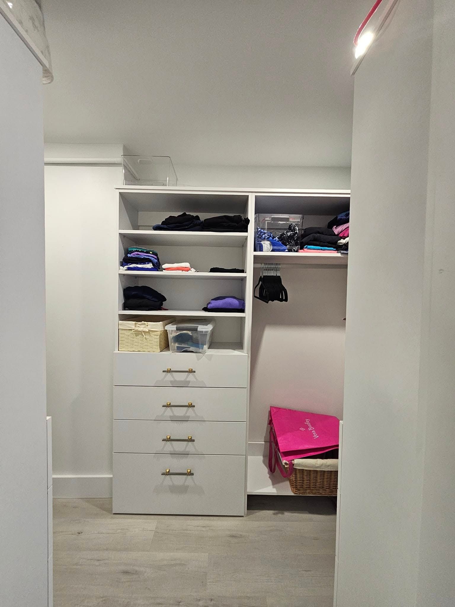 A walk in closet with lots of shelves and drawers filled with clothes.