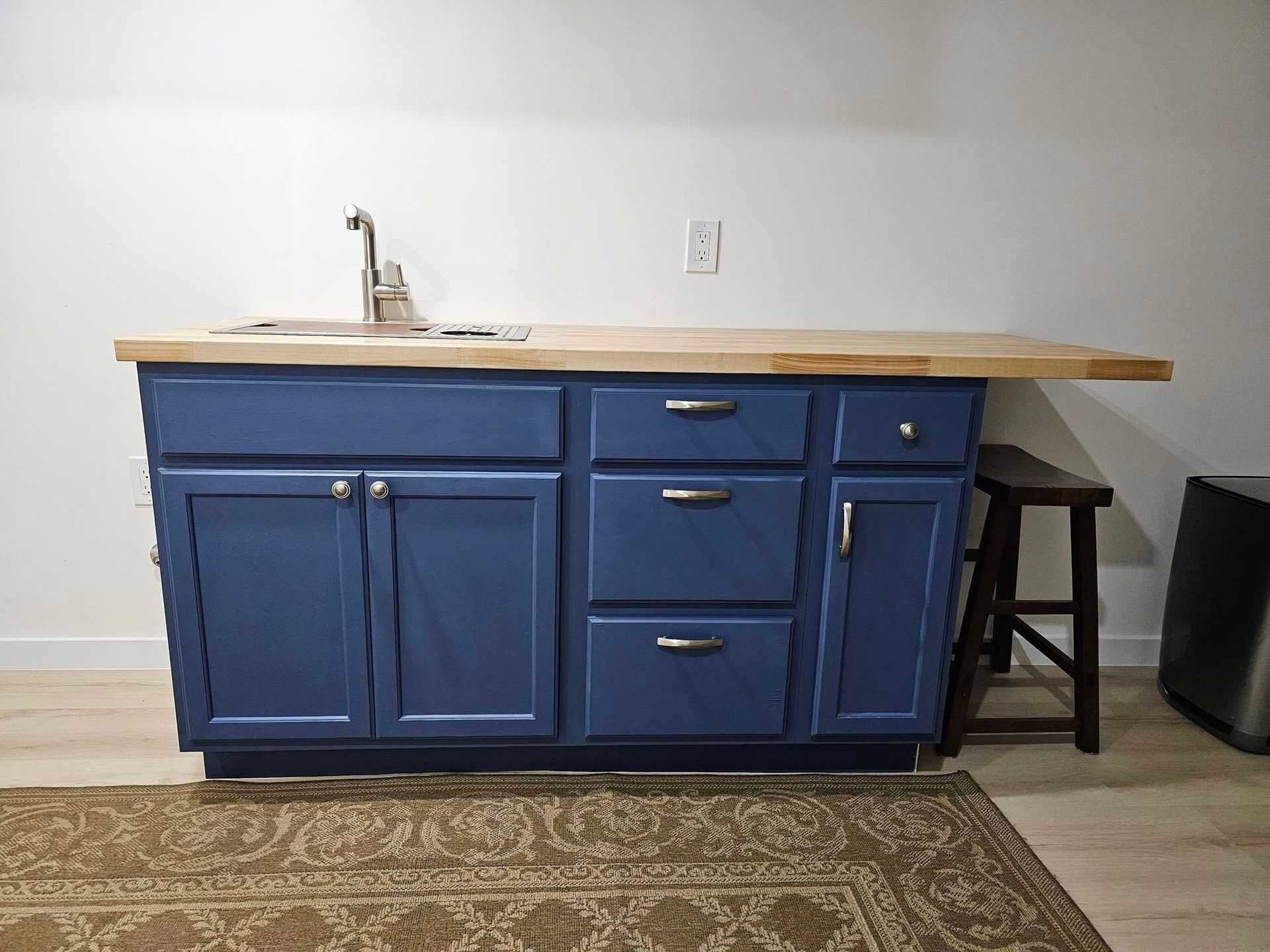 A kitchen with blue cabinets , drawers , and a sink.