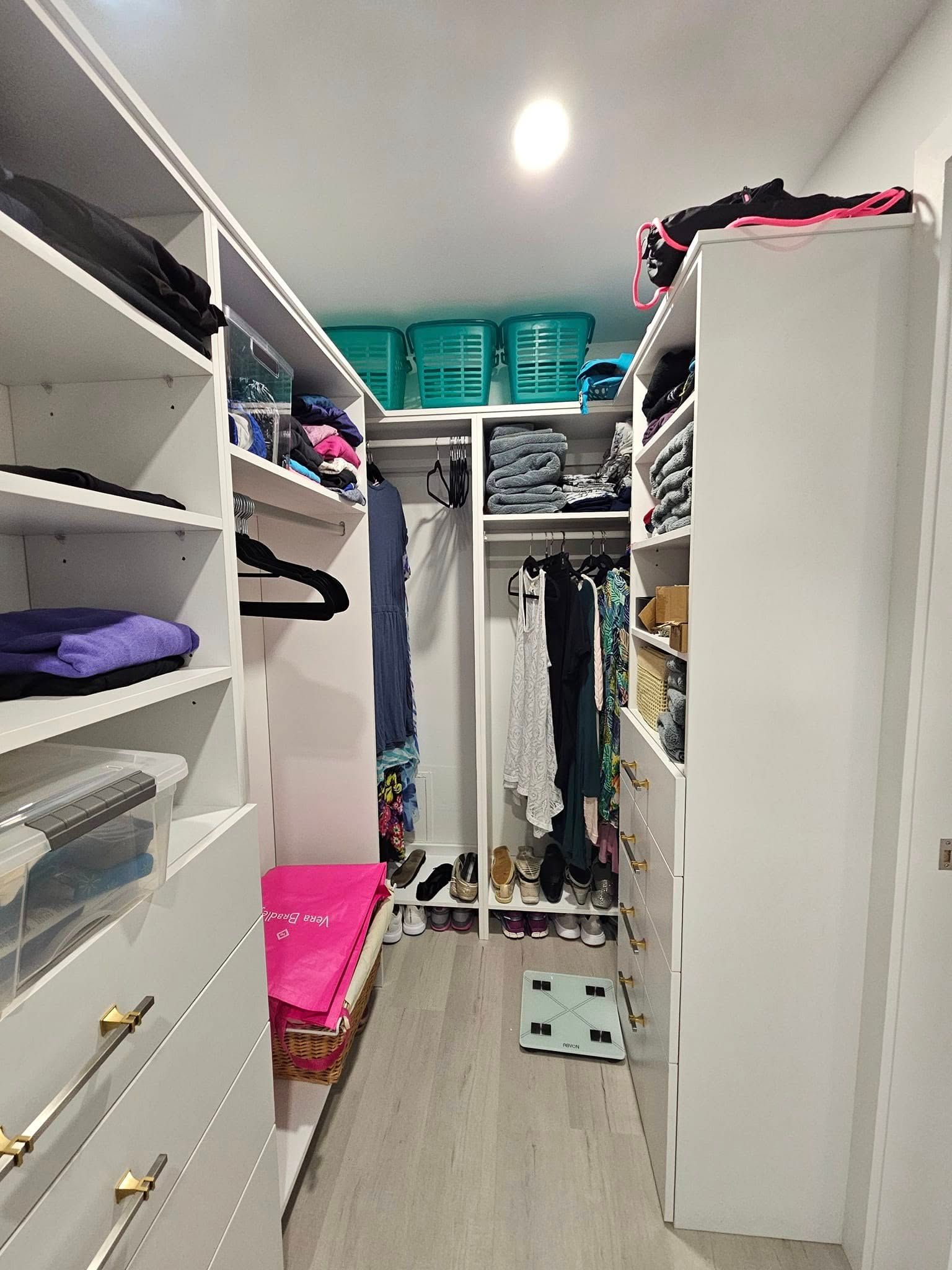 A walk in closet filled with lots of clothes and baskets.