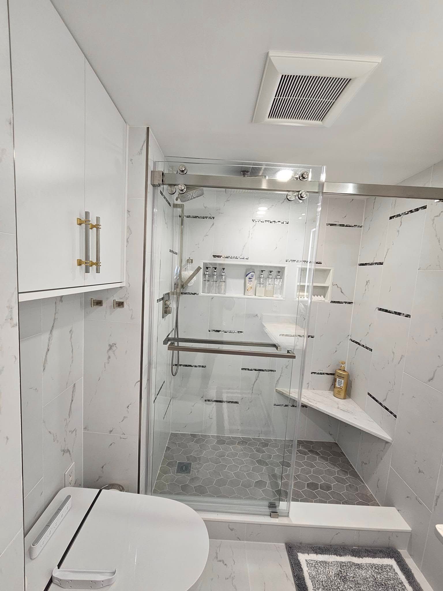 A bathroom with a toilet and a walk in shower.