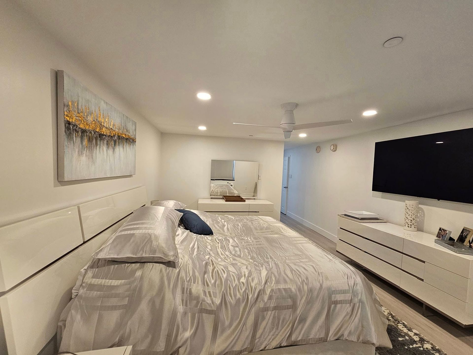 A bedroom with a large bed and a flat screen tv.
