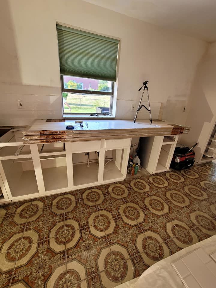 A kitchen under construction with a tile floor and a window.
