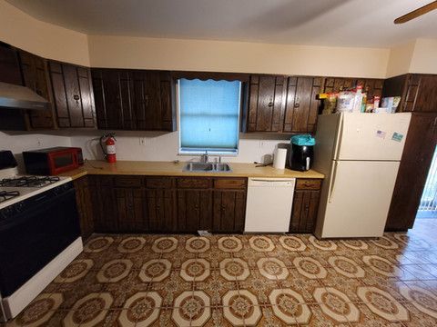 A kitchen with a stove , refrigerator , dishwasher , and sink.