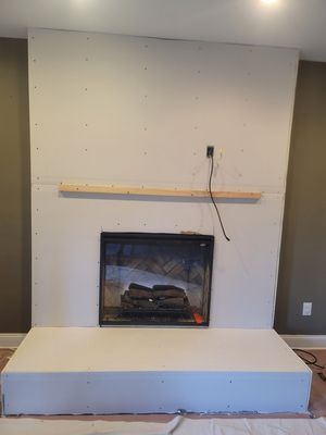 A fireplace is being built in a living room.