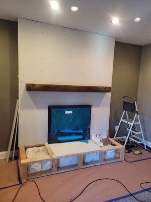 A fireplace is being built in a living room.