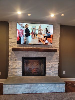 A living room with a fireplace and a flat screen tv on the wall.