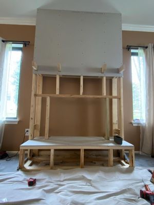 A fireplace is being built in a living room.