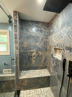 A bathroom with a walk in shower and a window.