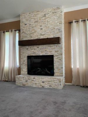 A living room with a fireplace and a flat screen tv.