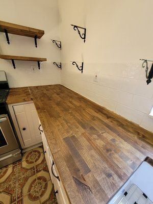 A kitchen with a wooden counter top and white cabinets.
