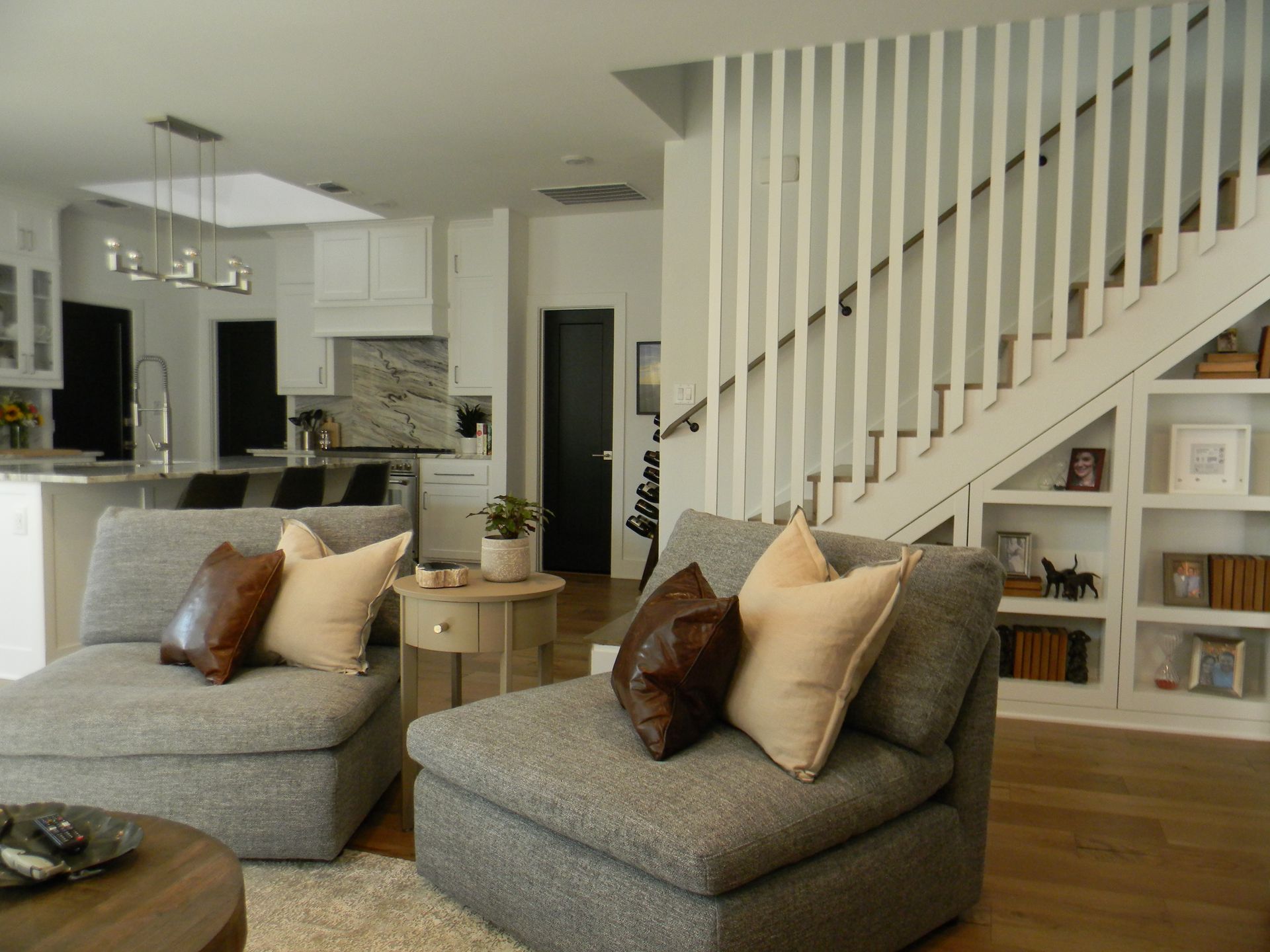 A living room with two chairs and a staircase in the background