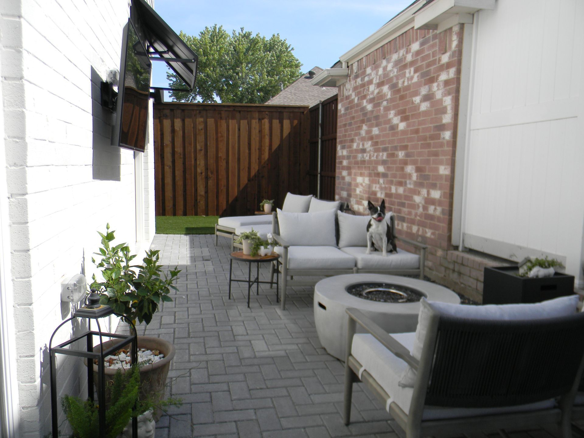 A patio with a couch and chairs and a fire pit