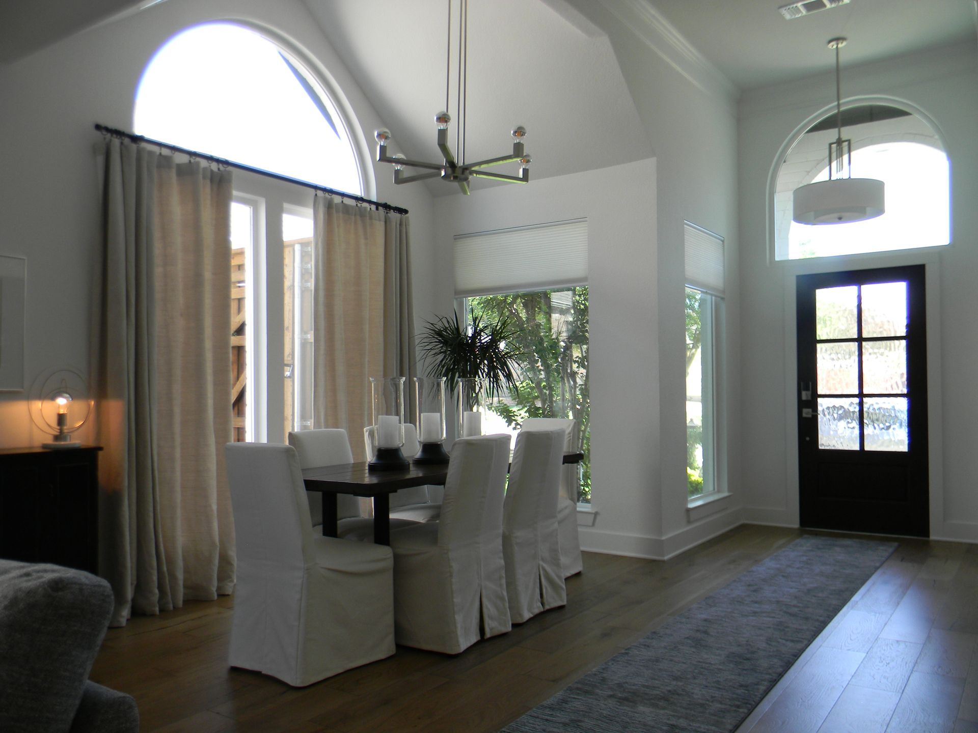 A dining room with a table and chairs and a black door
