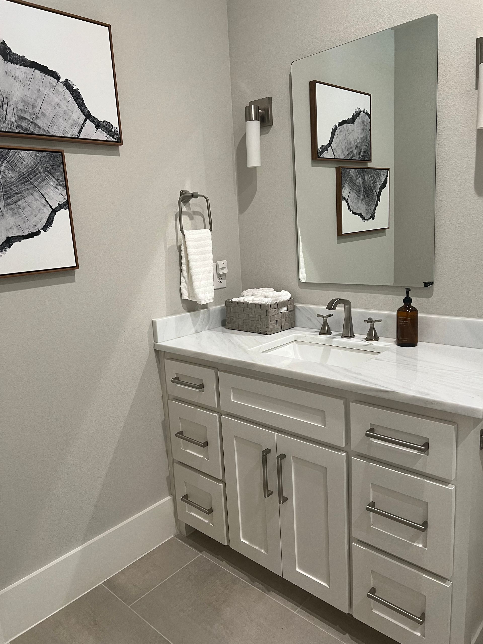 A bathroom with a sink , mirror and drawers