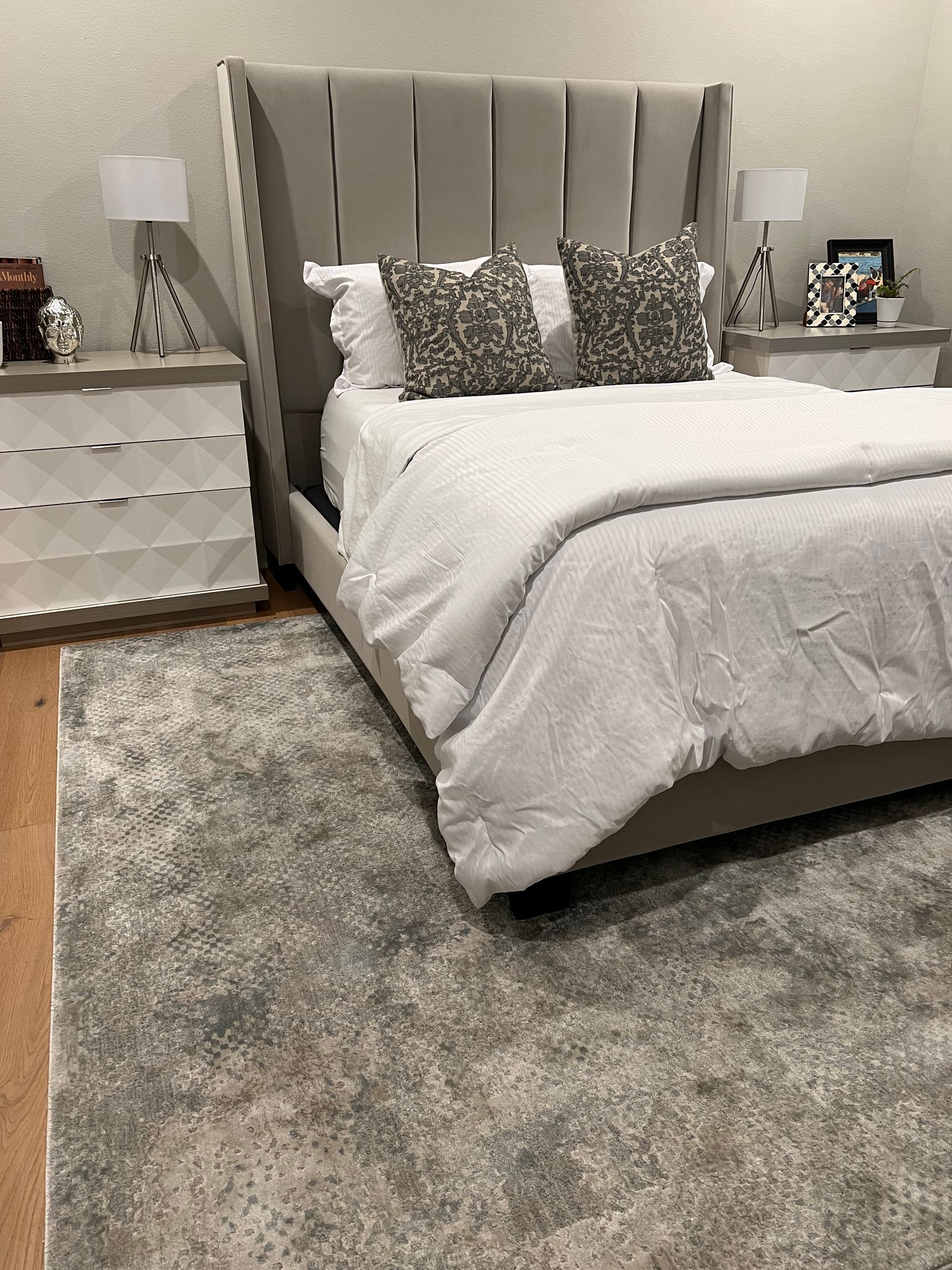 A bedroom with a bed , nightstand , and rug.
