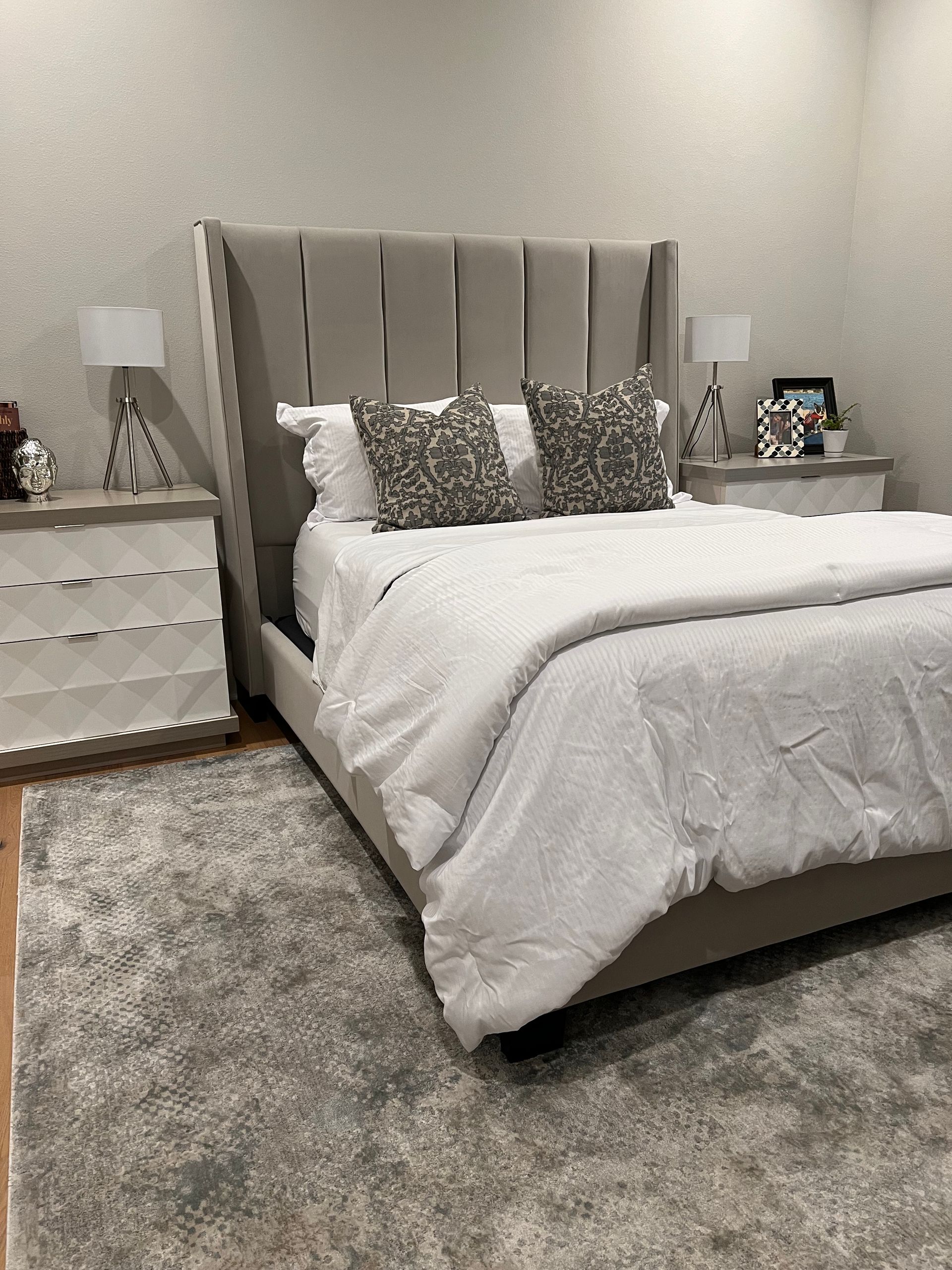 A bedroom with a bed , nightstands , and a rug.