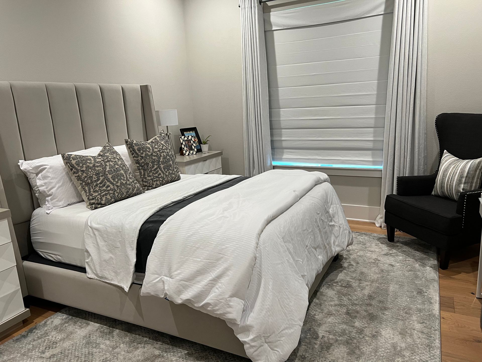 A bedroom with a bed , chair and window.