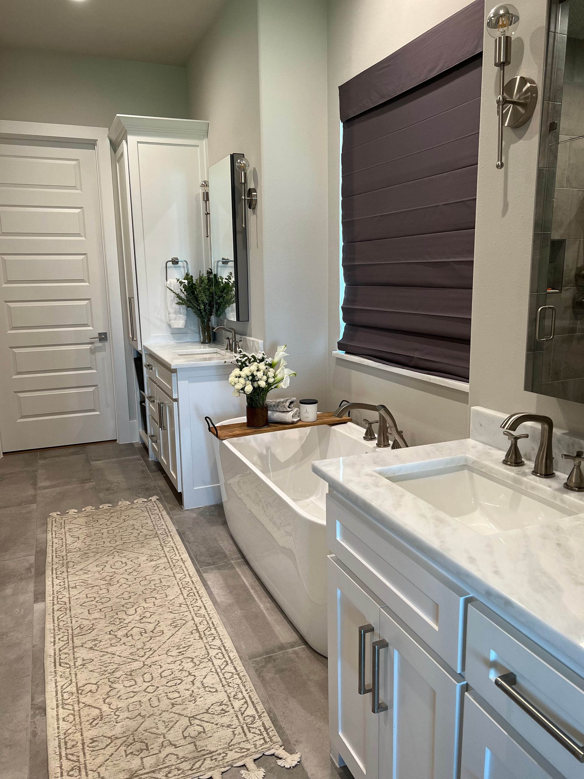 A bathroom with two sinks , a tub , and a window.