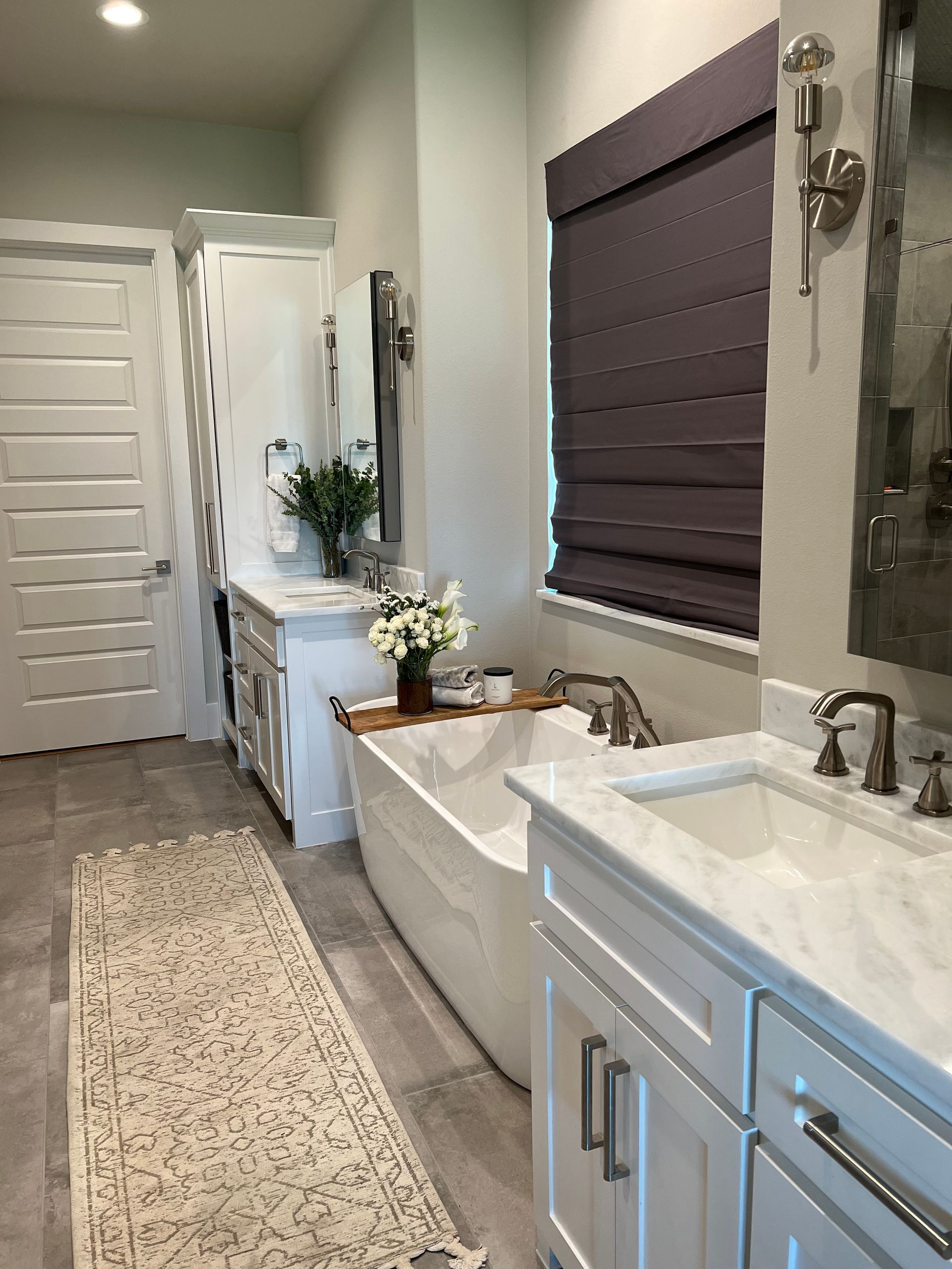 A bathroom with a tub , sink , and mirror.
