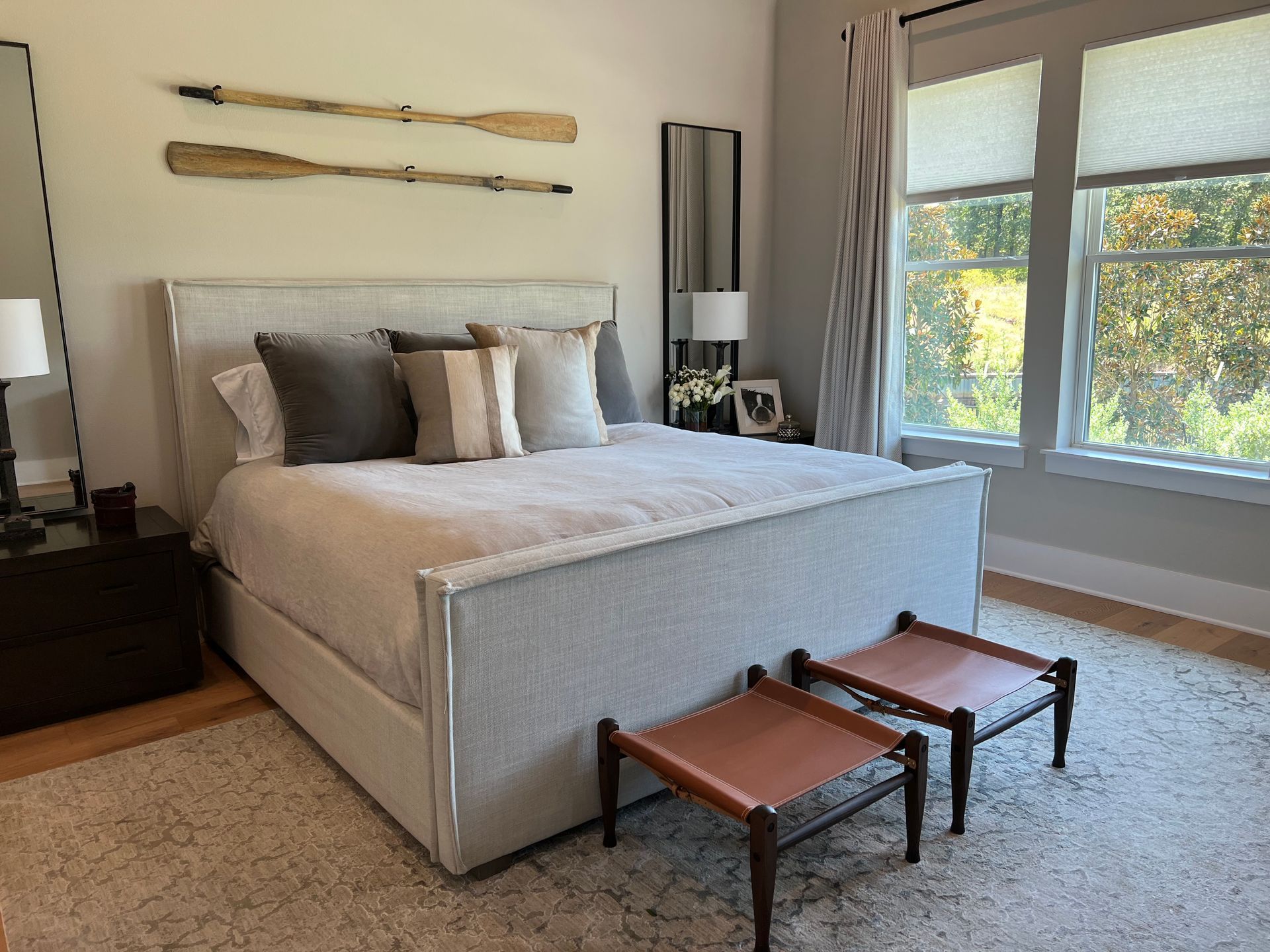 A bedroom with a large bed and two ottomans