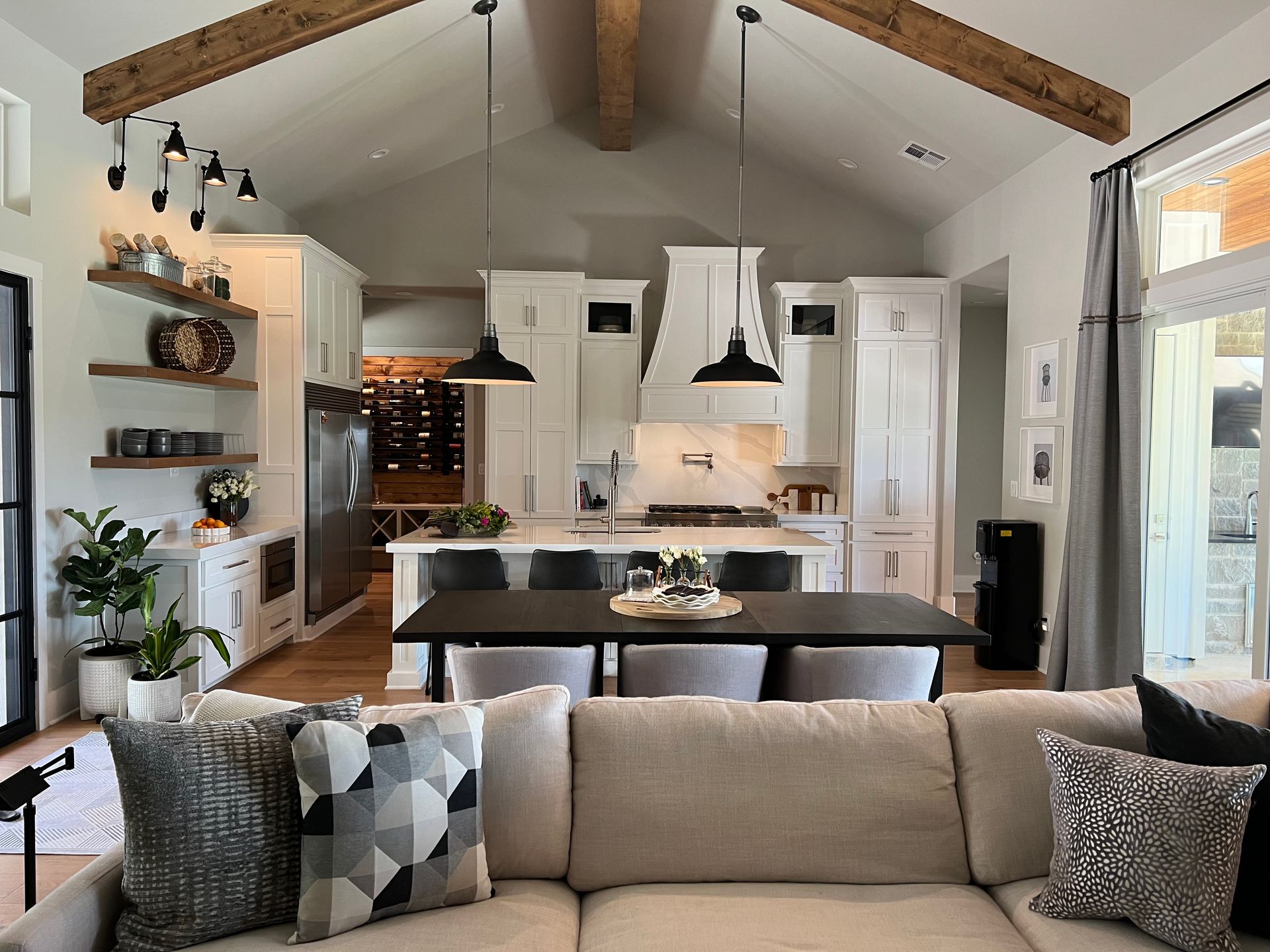 A living room with a couch and a table and a kitchen in the background.