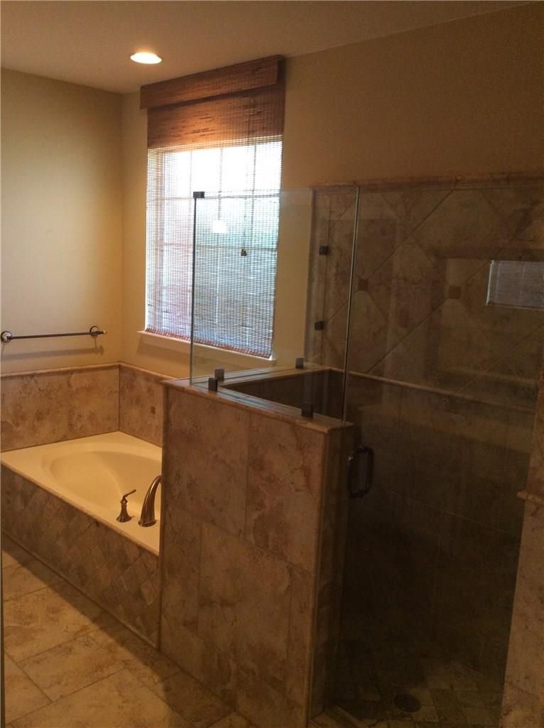 A bathroom with a tub and a walk in shower