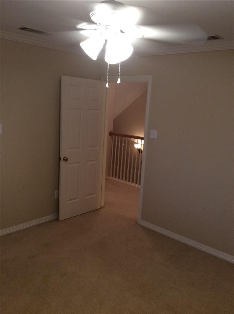 An empty room with a ceiling fan and a door