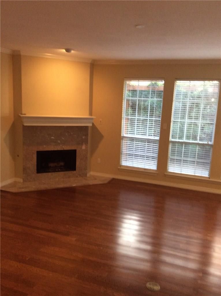 An empty living room with a fireplace and windows