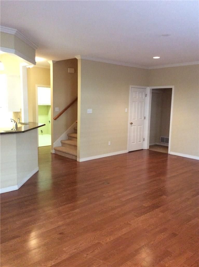 An empty living room with hardwood floors and stairs