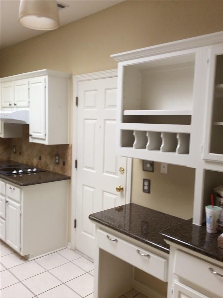 A kitchen with white cabinets and granite counter tops