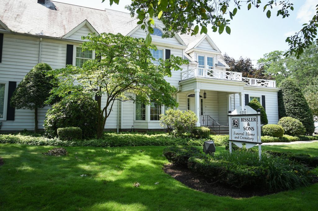 A large white house with a sign in front of it