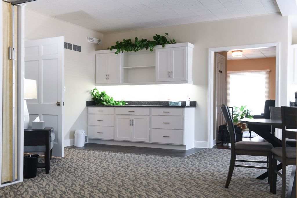 A living room with white cabinets and a table and chairs